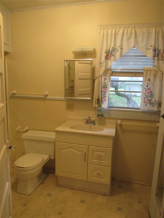 101 East Murray Street Denison, TX 75021 - Photo 27 of 32 a bathroom with a granite countertop toilet sink and mirror