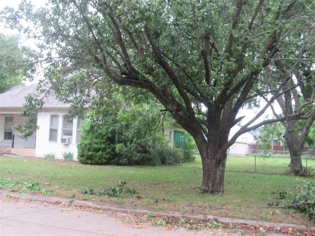 a view of a house with a tree in the yard