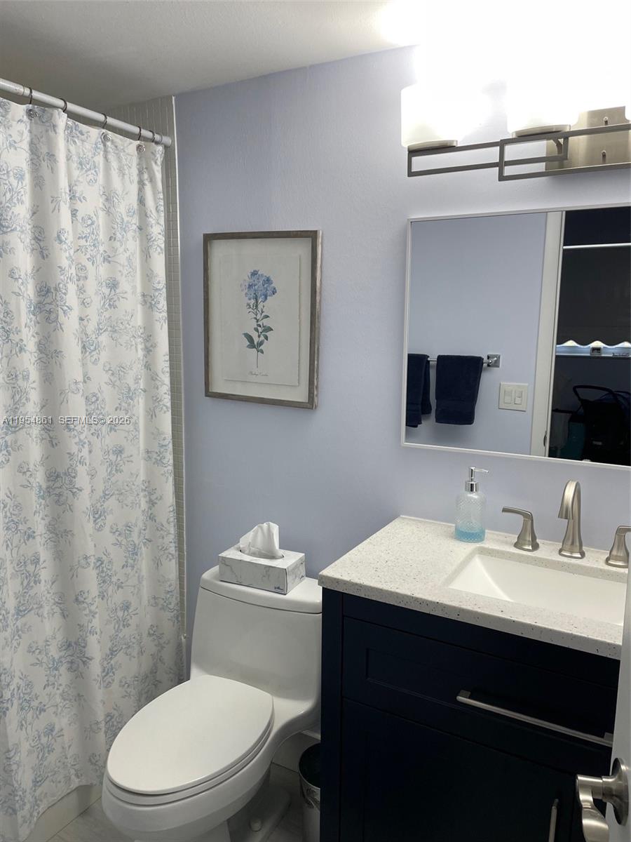 555 Northwest 4th Avenue, Unit 4150 Boca Raton, FL 33432 - Photo 6 of 17 a bathroom with a toilet a sink and a mirror