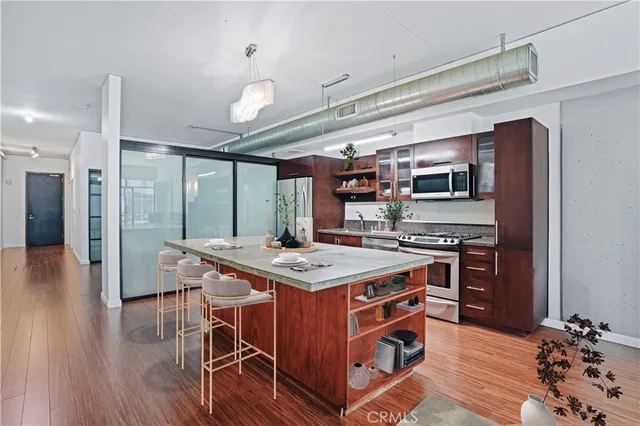 a kitchen that has a stove and a wooden floor