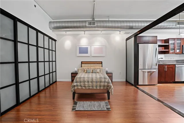 a view of kitchen with refrigerator and wooden floor