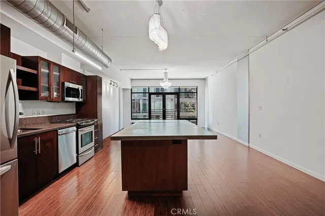 a kitchen with stainless steel appliances granite countertop a stove and a wooden floors