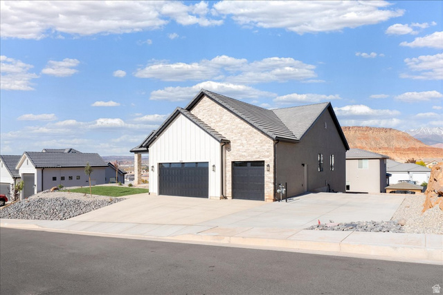 1491 East Centaurus Way, Unit 86 Washington, UT 84780 - Photo 21 of 26 View of front of house with a garage, concrete driveway, board and batten siding, and stone siding