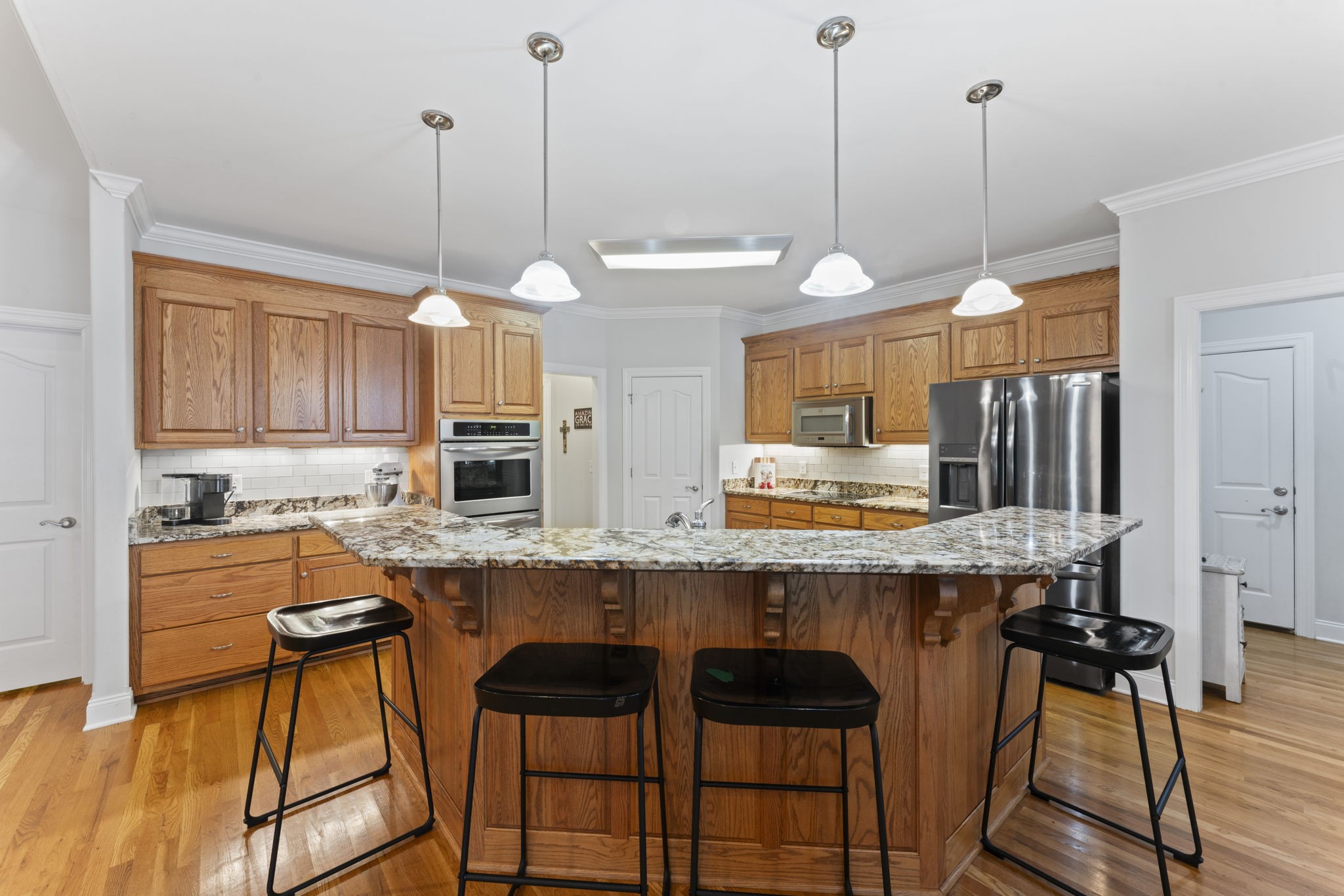11237 Newtown Road Unionville, TN 37180 - Photo 19 of 46 a kitchen with granite countertop wooden floors and white cabinets