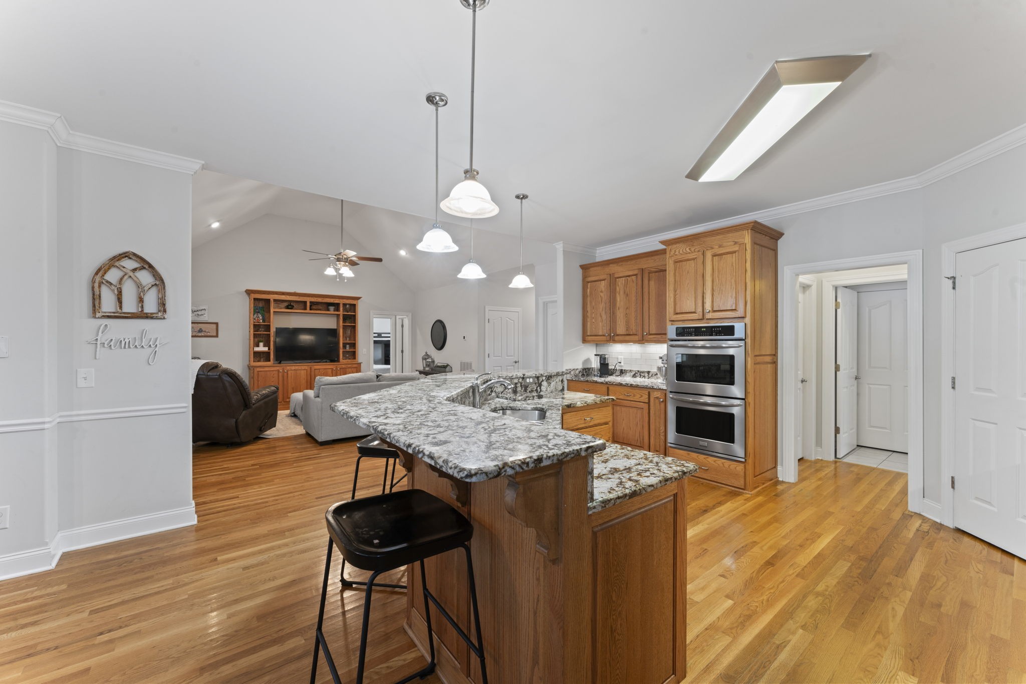 11237 Newtown Road Unionville, TN 37180 - Photo 20 of 46 a open kitchen with a refrigerator a stove a sink dishwasher and wooden cabinets with wooden floor