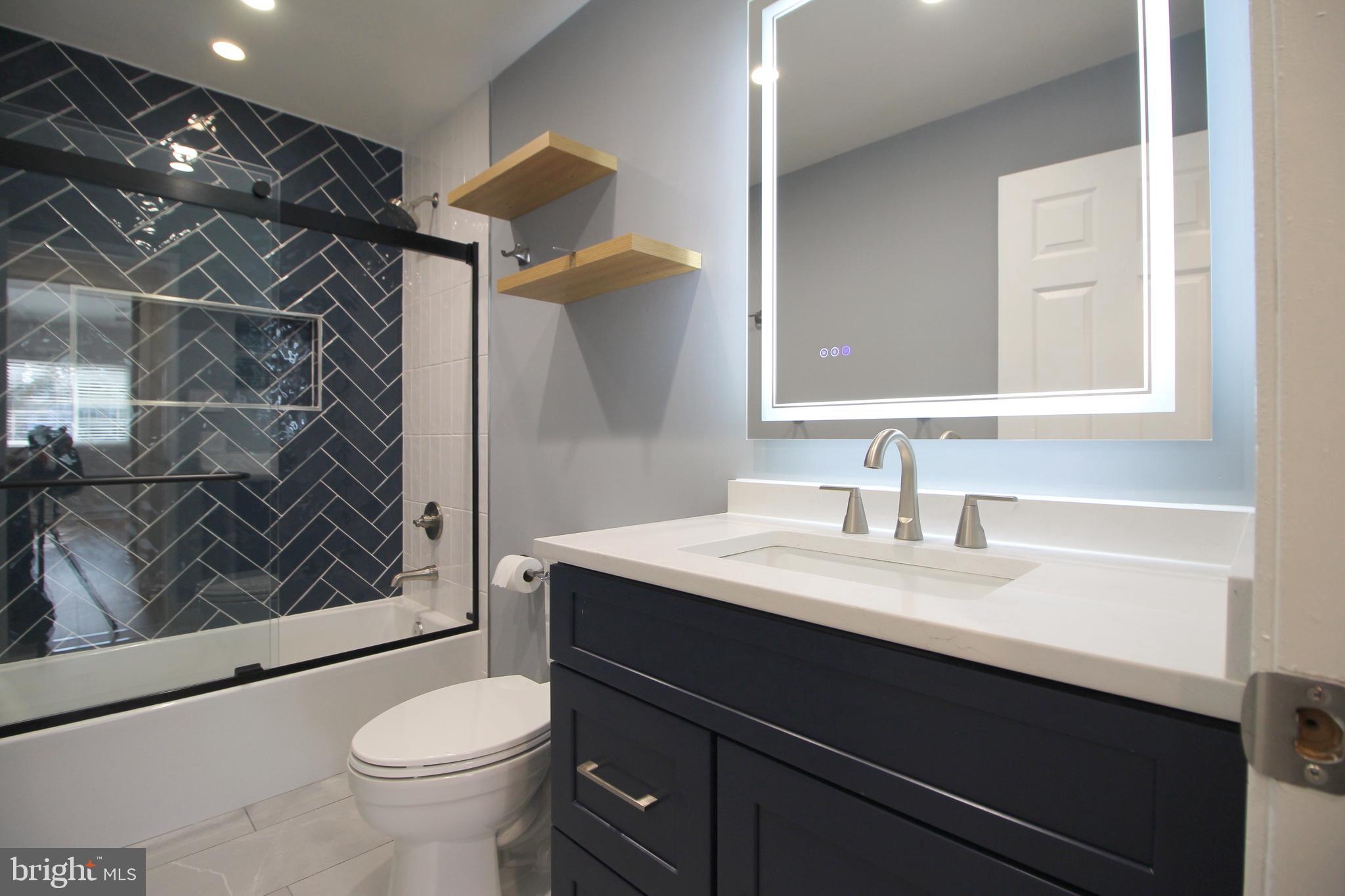 1956A Villaridge Drive, Unit 1956B Reston, VA 20191 - Photo 22 of 24 a bathroom with a sink vanity granite toilet and a mirror