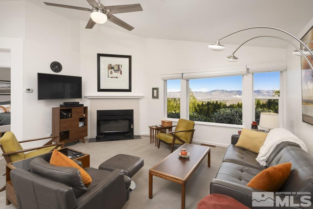 6238 Golden Meadow Road Reno, NV 89519 - Photo 21 of 40 a living room with furniture a fireplace and a flat screen tv
