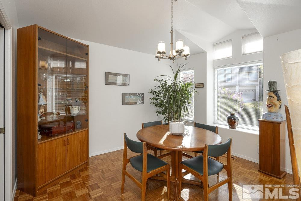 6238 Golden Meadow Road Reno, NV 89519 - Photo 7 of 40 a dining room with furniture a chandelier and wooden floor