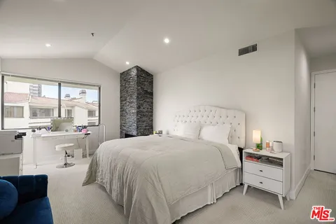 a spacious bedroom with a bed and a large window