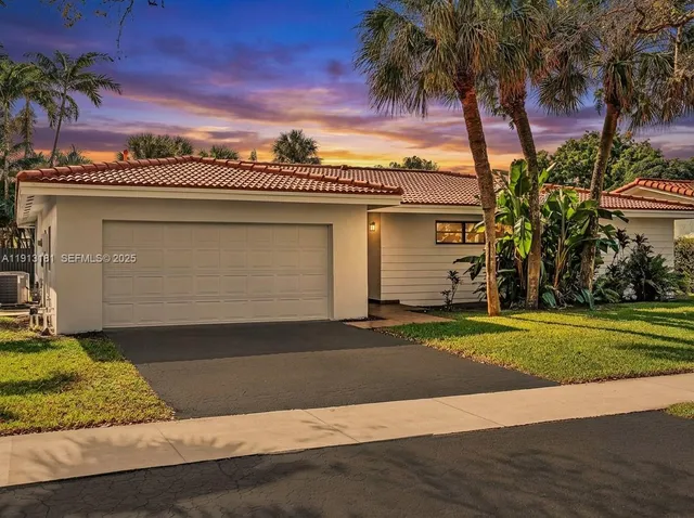 a view of a house with a yard and palm trees