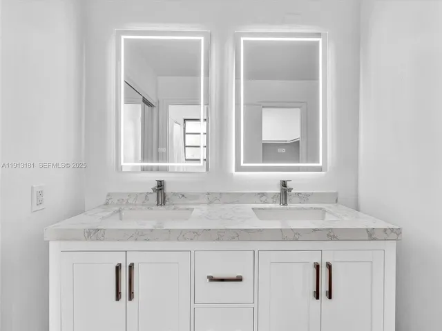 a bathroom with a granite countertop sink double and mirror