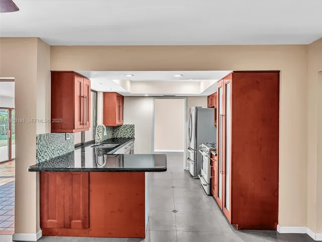 a kitchen with stainless steel appliances granite countertop a refrigerator and a sink
