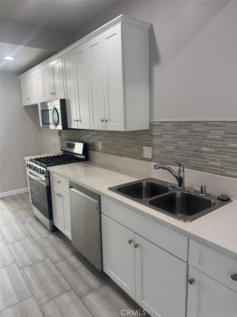 13665 Arrow Route, Unit 6 Fontana, CA 92335 - Photo 16 of 42 a kitchen with stainless steel appliances granite countertop a sink a stove a microwave and cabinets