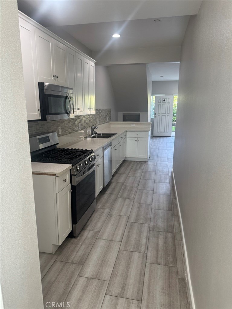 13665 Arrow Route, Unit 6 Fontana, CA 92335 - Photo 21 of 42 a kitchen with granite countertop a stove top oven and cabinets