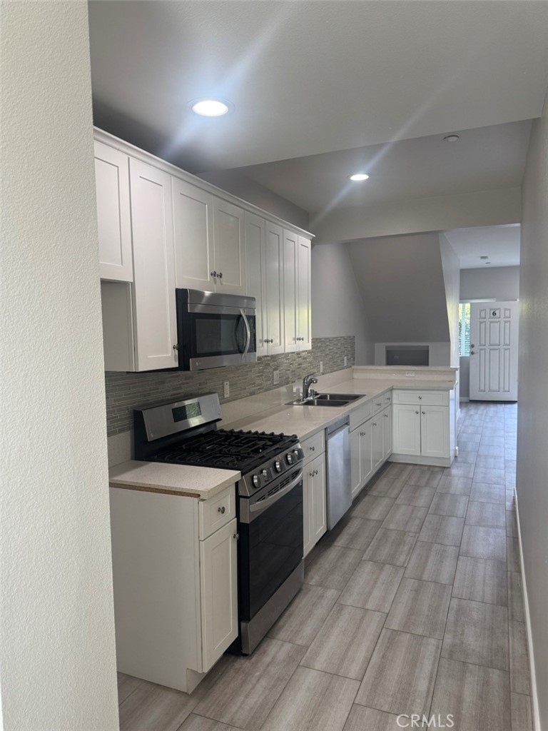 13665 Arrow Route, Unit 6 Fontana, CA 92335 - Photo 22 of 42 a kitchen with stainless steel appliances granite countertop a stove top oven a sink dishwasher and a refrigerator