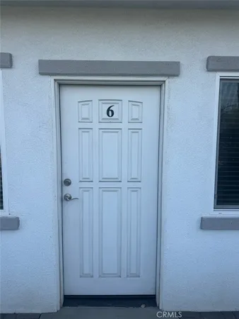 an empty room with wooden floor and a kitchen