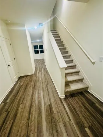 a view of a hallway with wooden floor and staircase