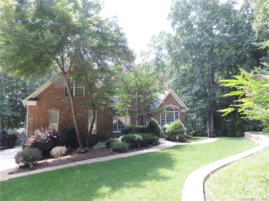 a front view of a house with a yard and a garden