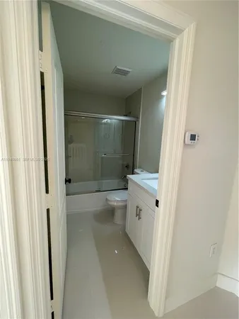 a bathroom with a granite countertop sink a toilet and shower