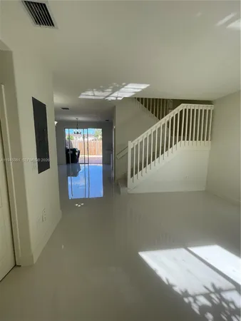 a view of staircase with railing and white walls