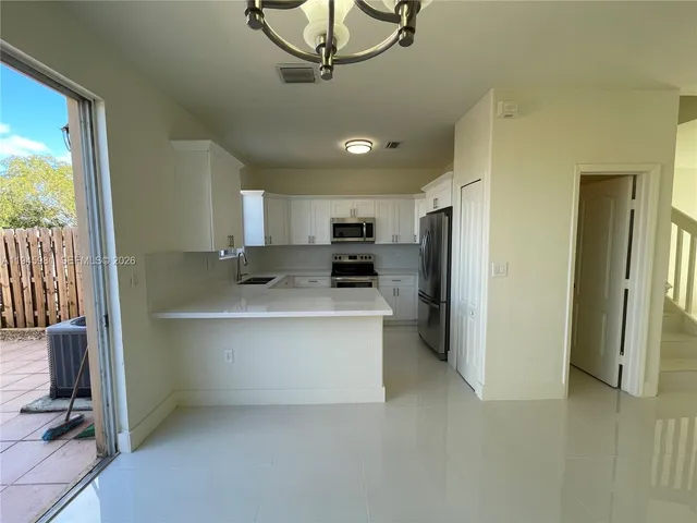 a kitchen with stainless steel appliances a refrigerator sink and microwave