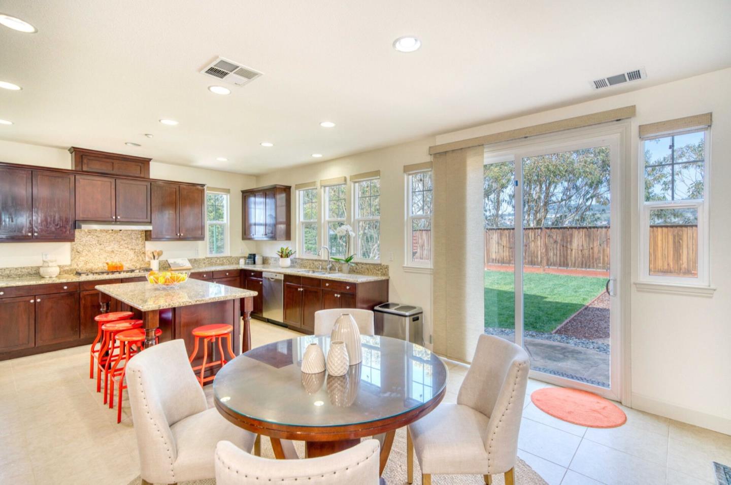 1 Connemara Drive Pacifica, CA 94044 - Photo 10 of 45 a open kitchen with stainless steel appliances granite countertop a stove a refrigerator a sink a dining table and chairs with the outer view