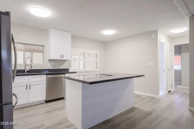 a kitchen with granite countertop a sink and a stove top oven