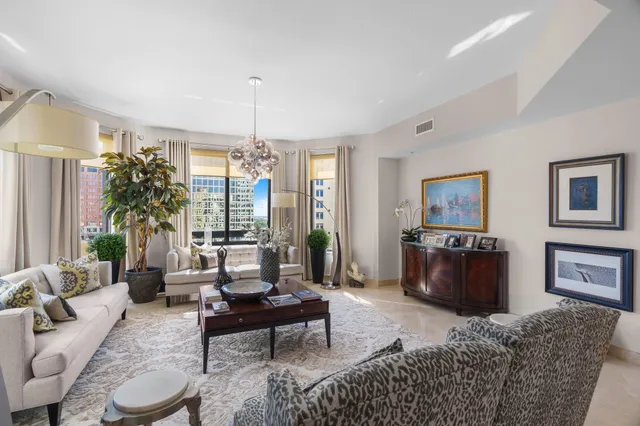 a living room with furniture a chandelier and a window
