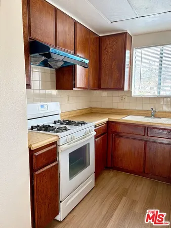 a kitchen with granite countertop wooden cabinets and a stove top oven