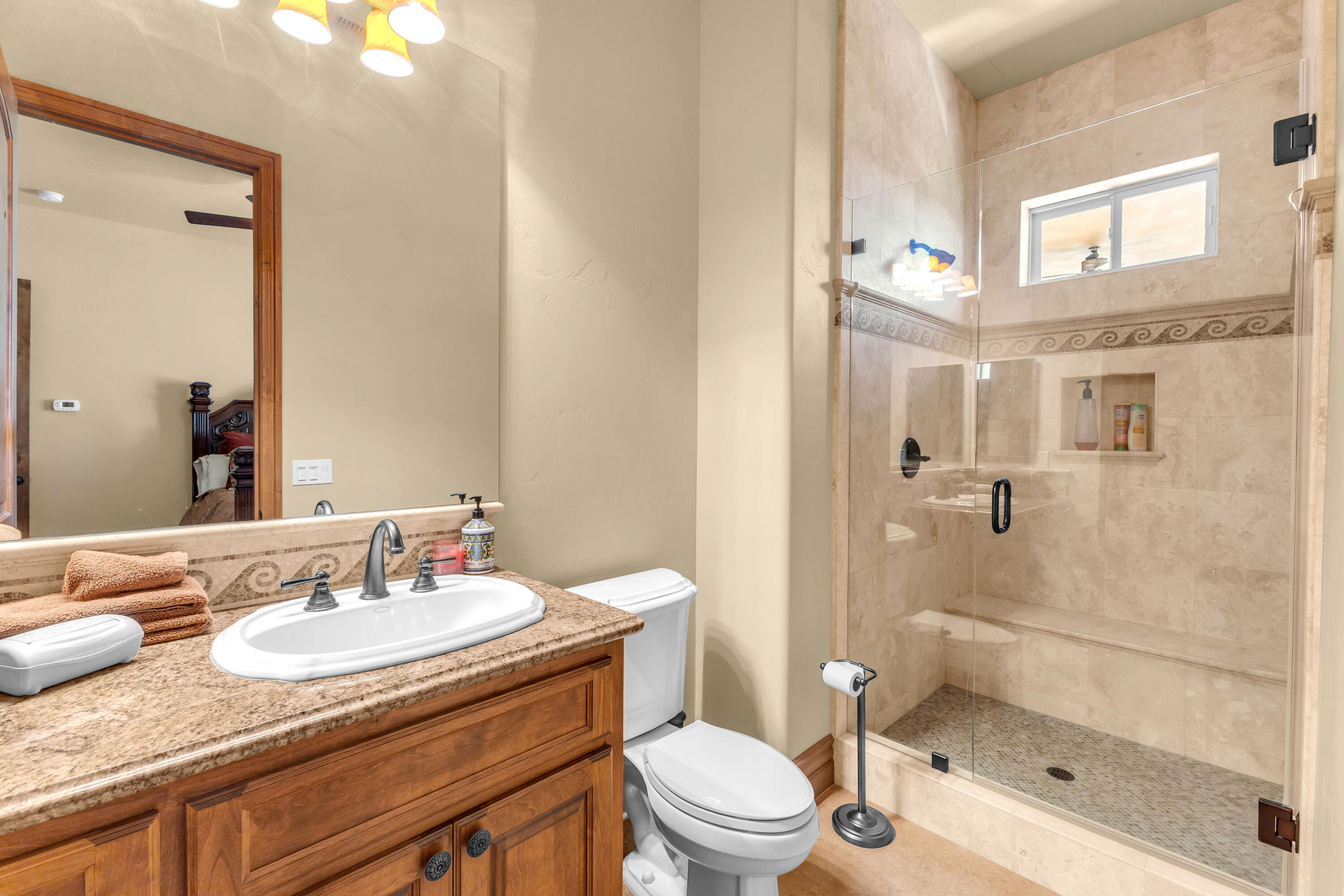 39345 San Ignacio Road Hemet, CA 92544 - Photo 63 of 110 a bathroom with a granite countertop sink a toilet a mirror and shower