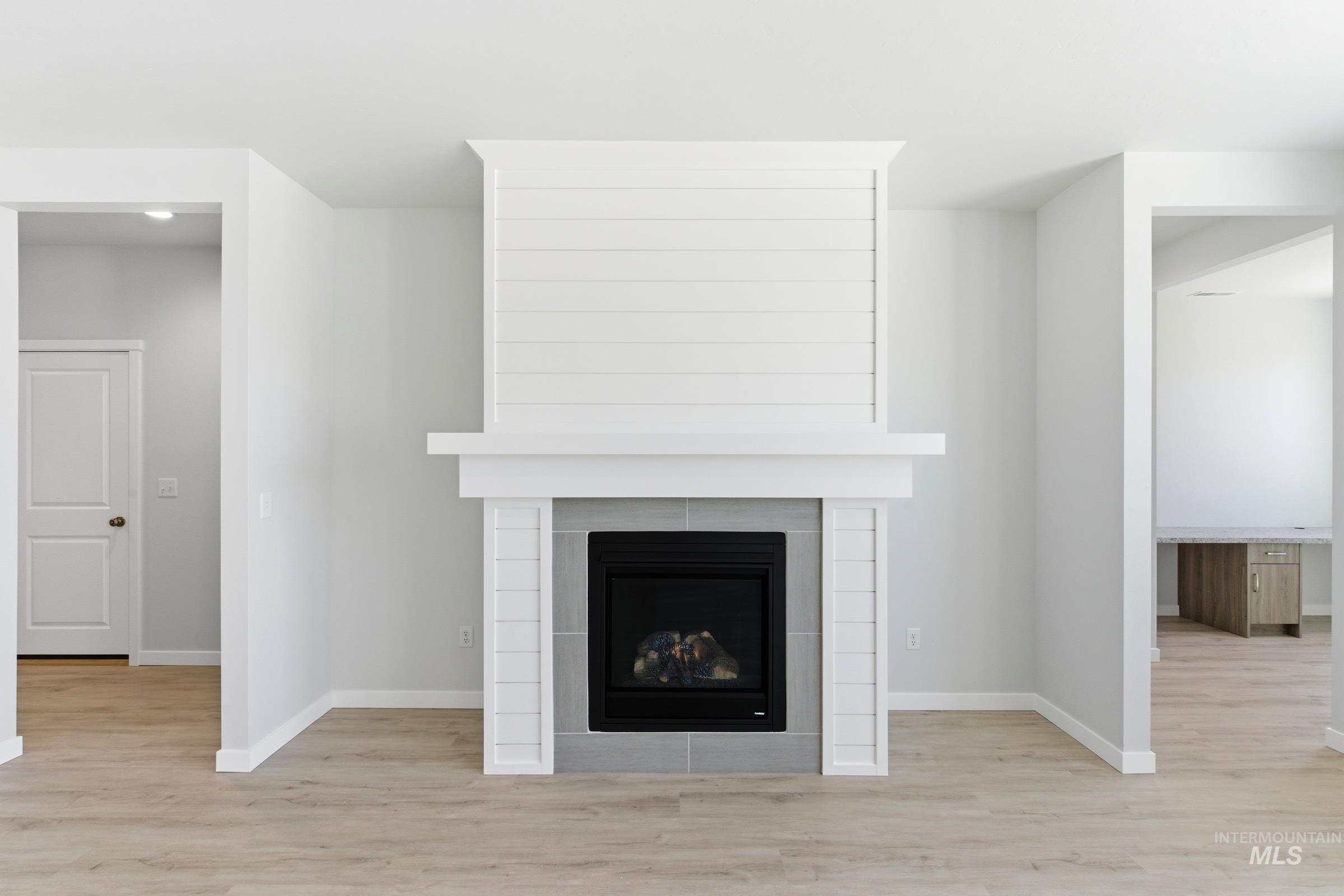 13663 Redway Court Caldwell, ID 83607 - Photo 11 of 32 Gas fireplace featuring a white shiplap-style mantel and a gray tiled surround