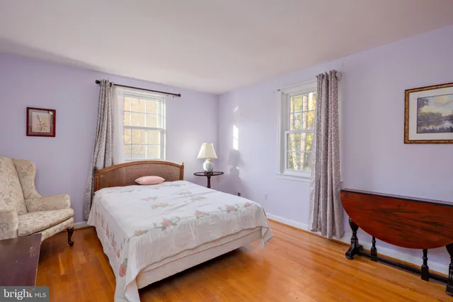 a bedroom with a bed wooden floor and a window