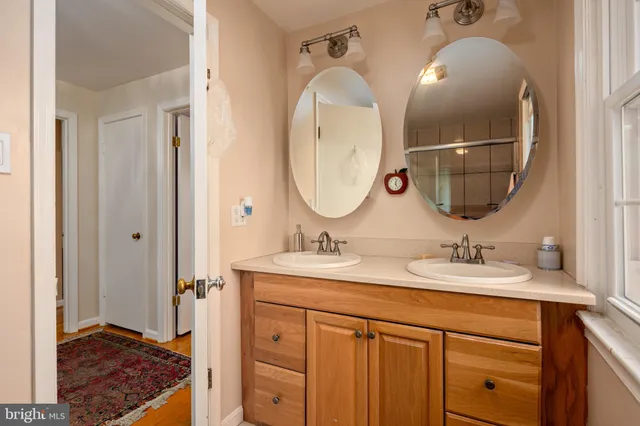 a en suite bathroom with a double vanity sink and a mirror