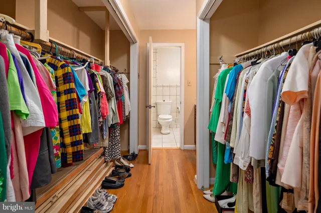 a view of walk in closet with clothes and shoes