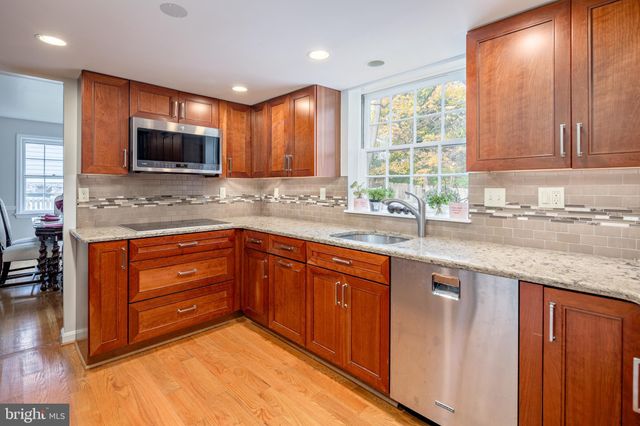 a kitchen with granite countertop a sink and a stove top oven