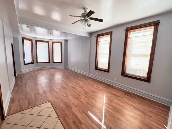 a view of n empty room with window and a kitchen view