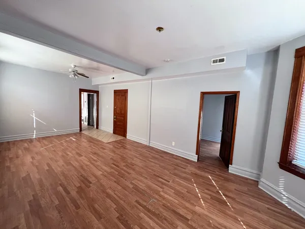 a view of empty room with wooden floor and fireplace