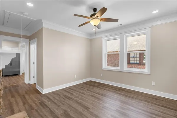 a view of an empty room with window and wooden floor