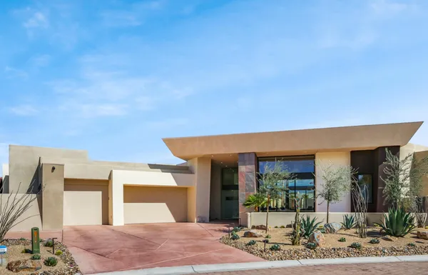 a front view of a house with garden and patio