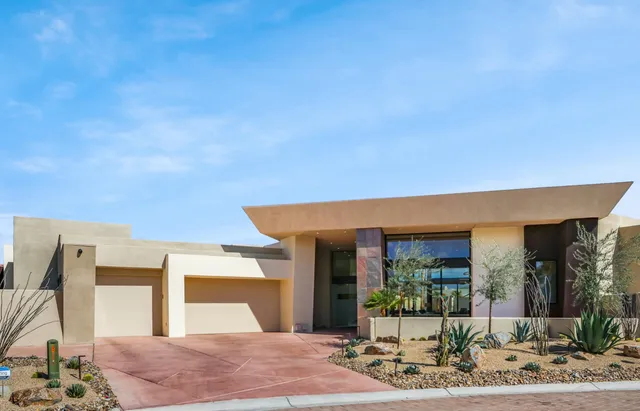 a front view of a house with garden and patio