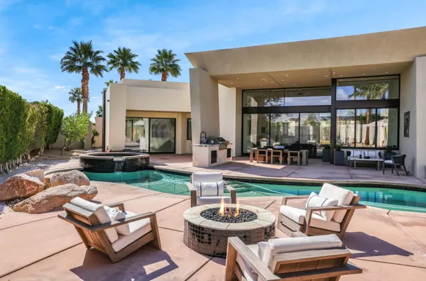 a view of a patio with couches table and chairs potted plants and palm tree