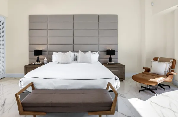 a bedroom with a bed and large windows