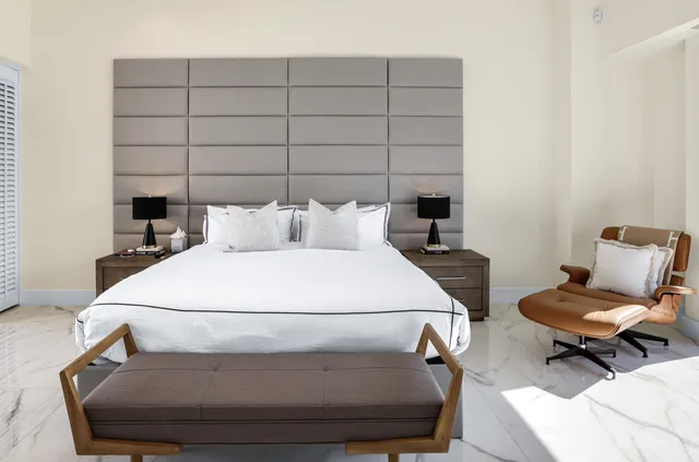 a bedroom with a bed and large windows