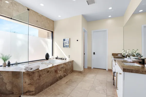 a bathroom with a tub sink and mirror
