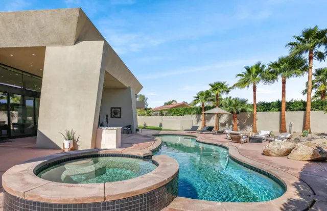 a view of a house with swimming pool and sitting area