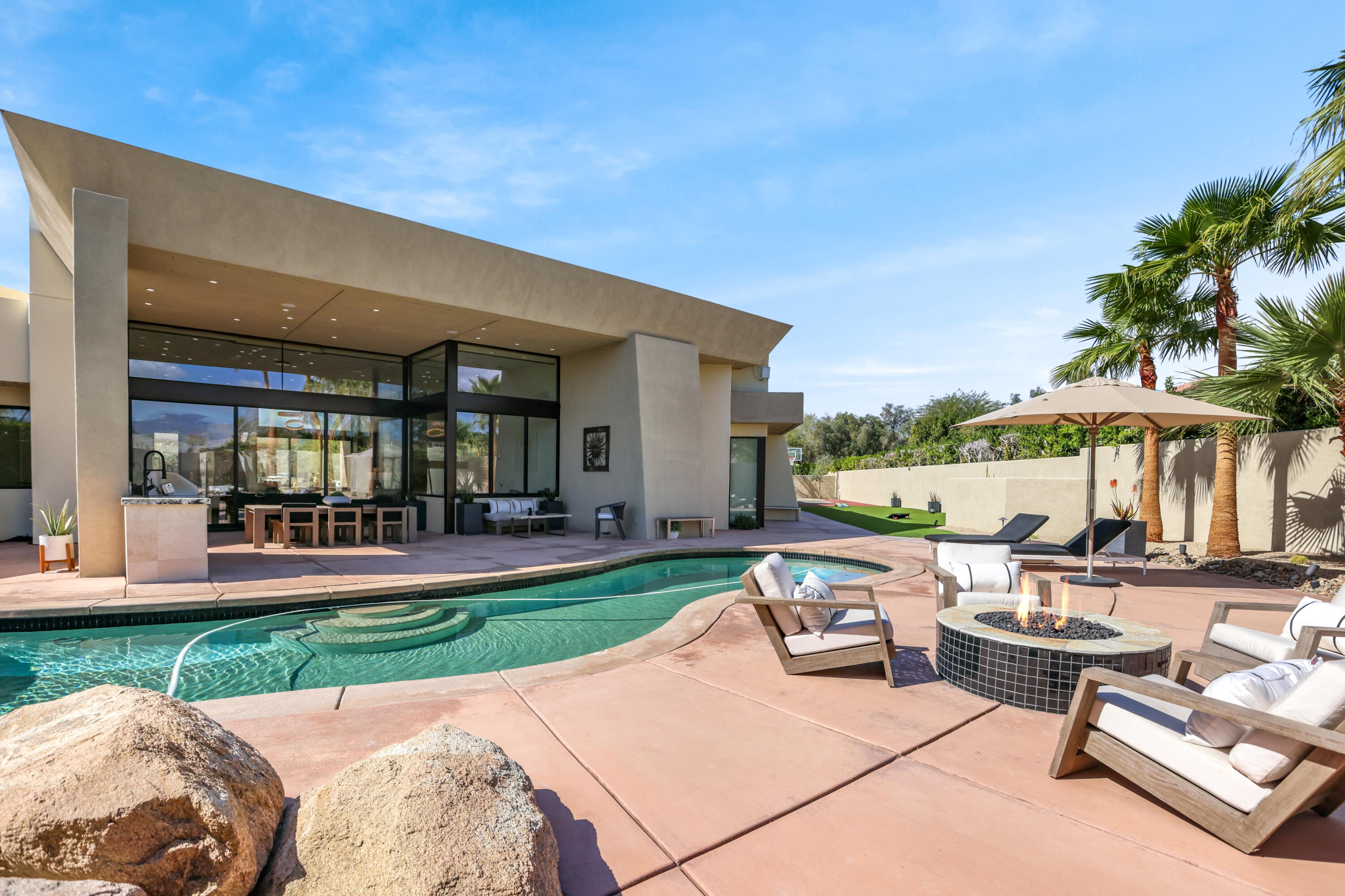 1 Seclude Court Rancho Mirage, CA 92270 - Photo 48 of 52 a view of a patio with couches and table and chairs under an umbrella