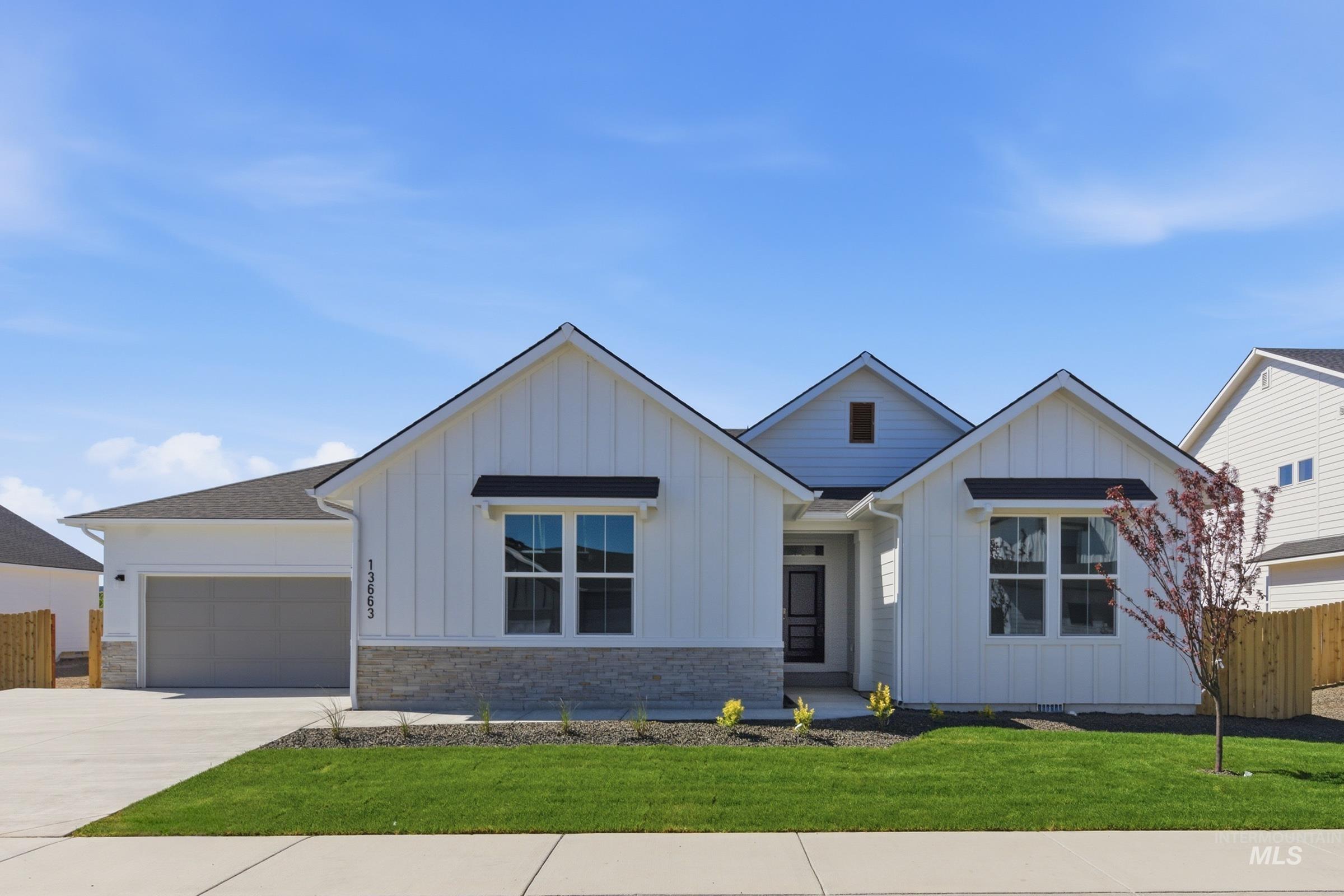 13663 Redway Court Caldwell, ID 83607 - Photo 1 of 32 Contemporary single-story residence featuring white board and batten siding, a dark asphalt shingle roof, and a stone veneer accent
