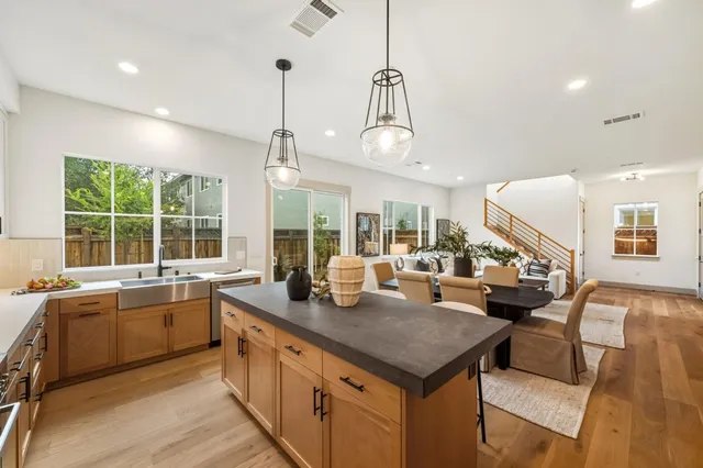 a kitchen with stainless steel appliances granite countertop a sink a stove and a wooden floors