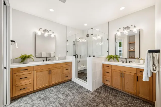a large bathroom with a double vanity sink a large mirror and shower