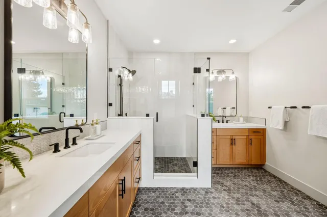 a bathroom with a double vanity sink mirror and shower